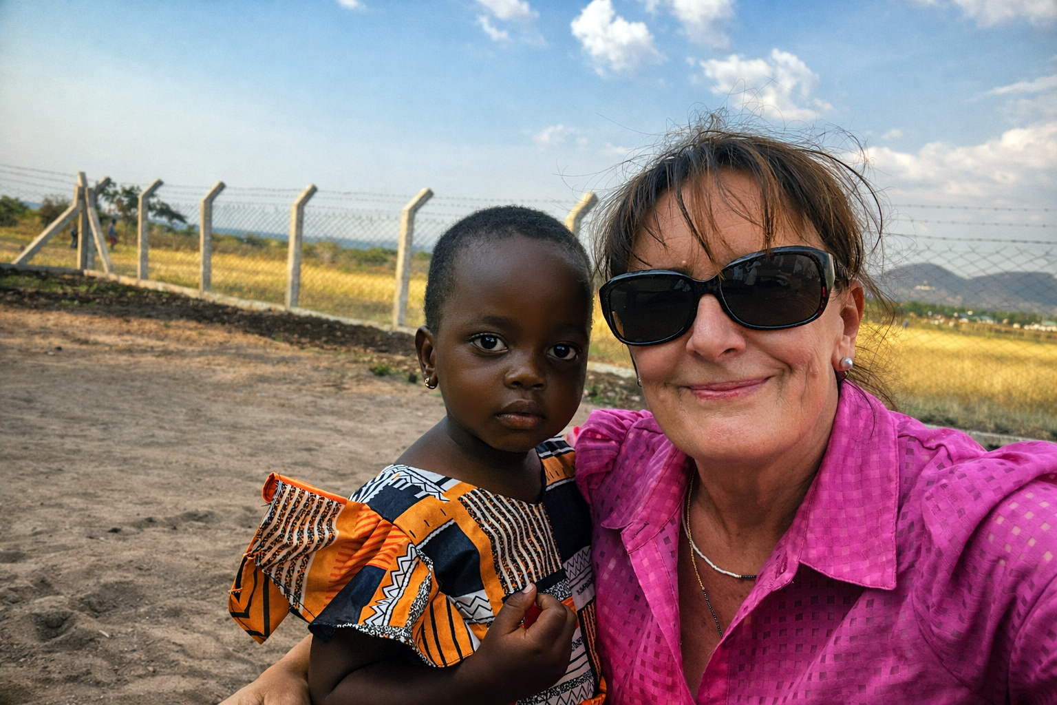Travel to Africa host smiling with a young child during a community visit in Africa