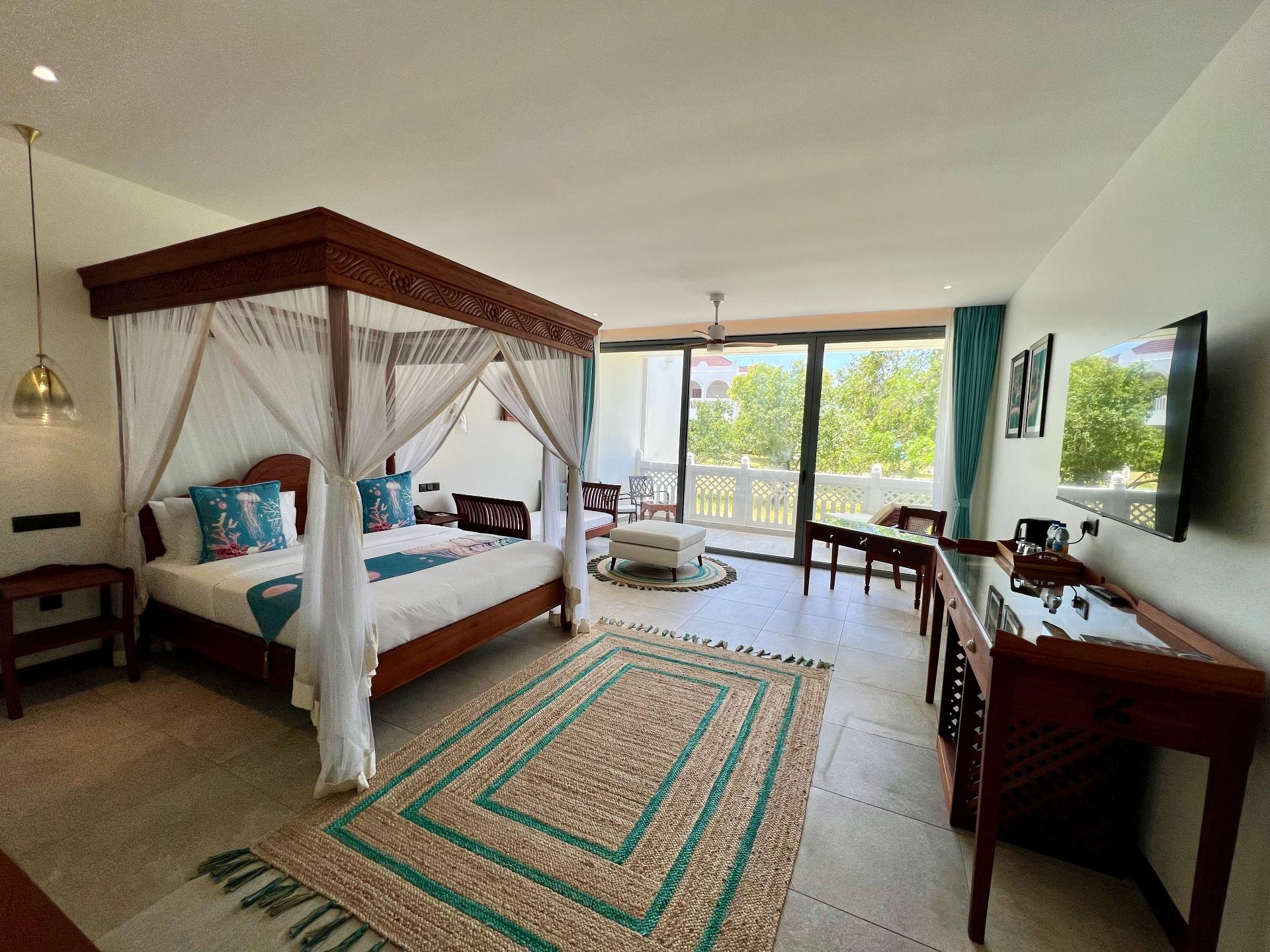 Spacious luxury room with four-poster bed and garden terrace