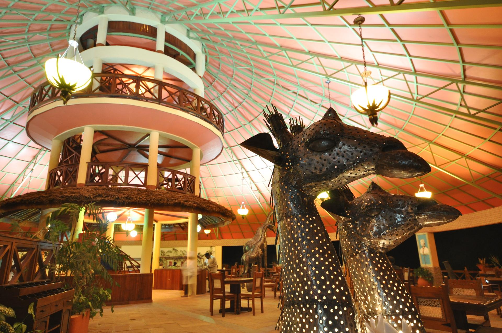 Dining area with giraffe sculptures at Kilima Safari Camp