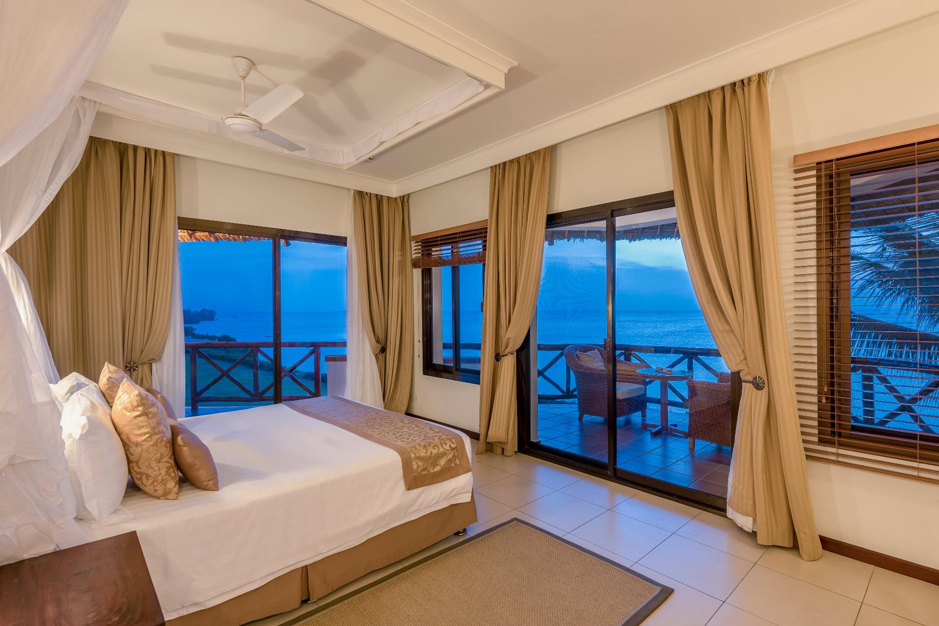 Luxury bedroom suite with balcony overlooking the ocean