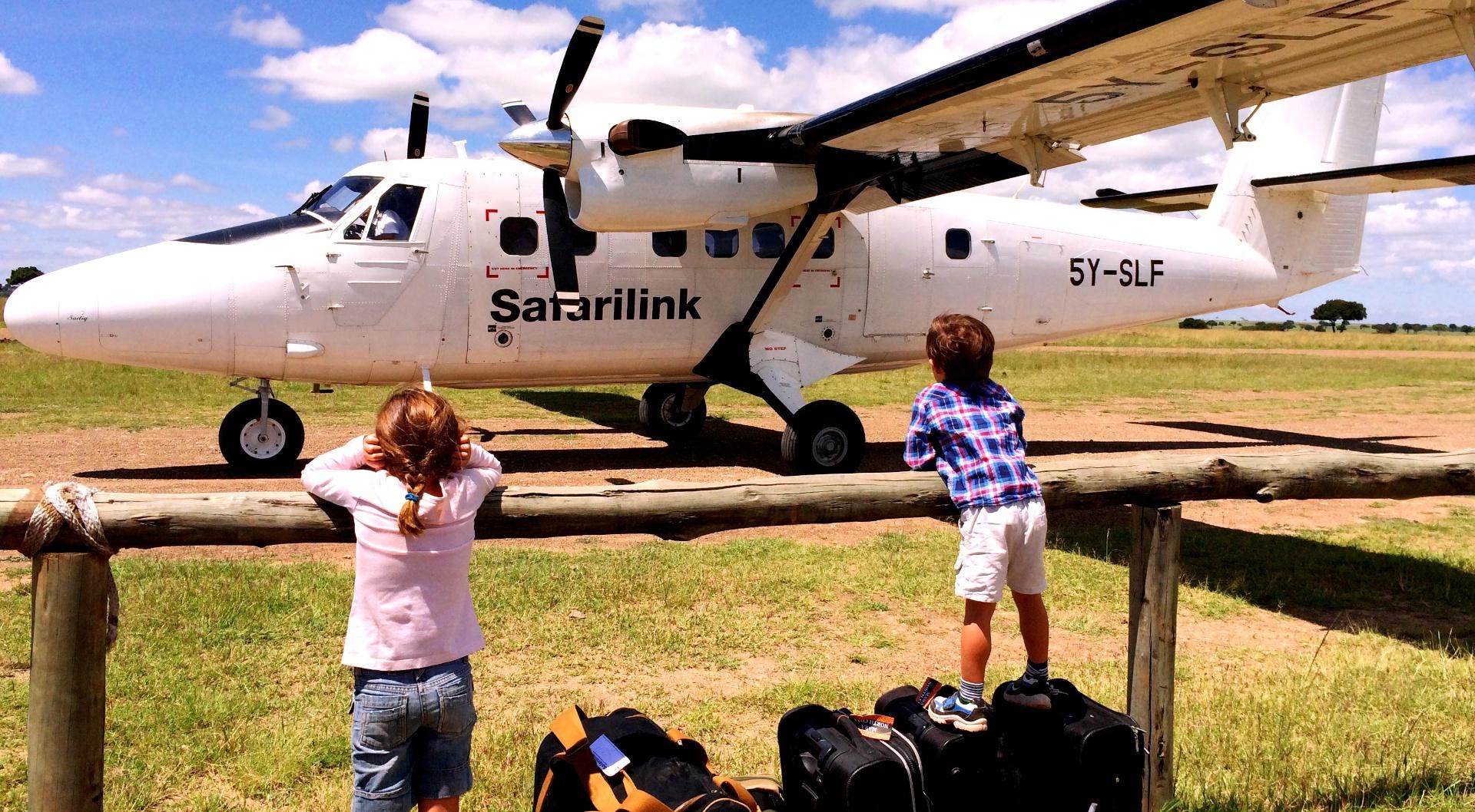 Children watching a Safarilink bush plane on an airstrip in the Masai Mara
