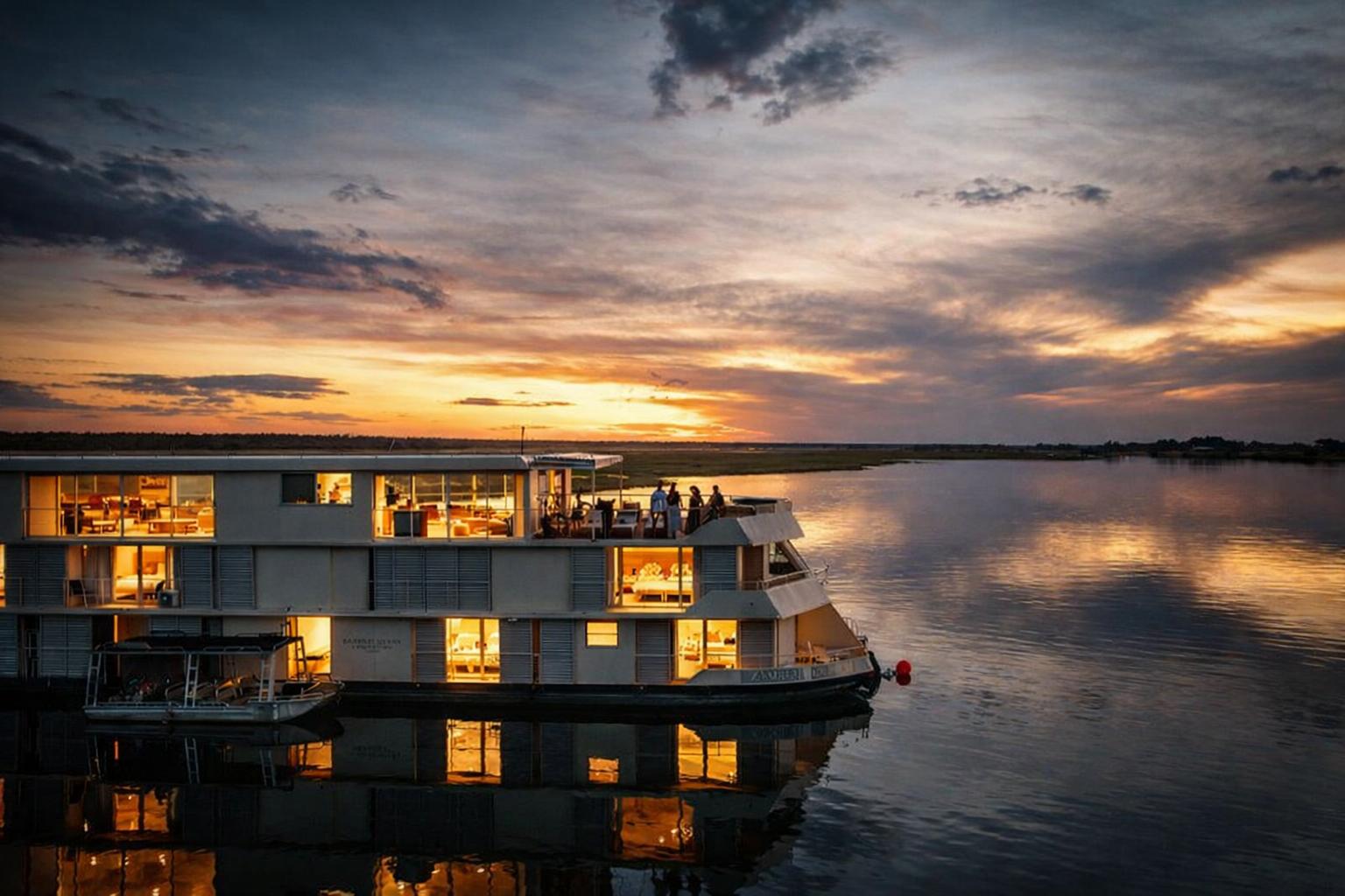 Zambezi Queen luxury floating boutique hotel glowing at sunset on the Chobe River